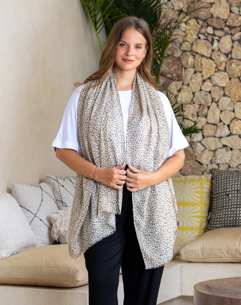 Woman wearing a leopard print scarf in a living room setting