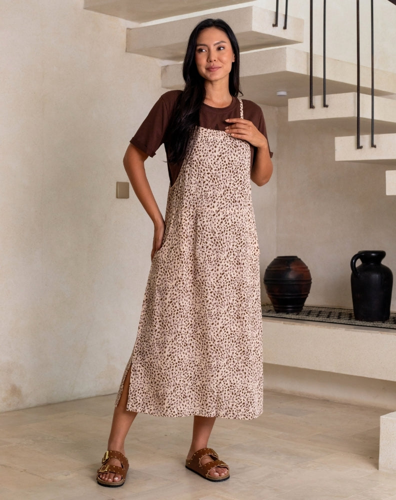Woman wearing a brown patterned dress in an indoor setting