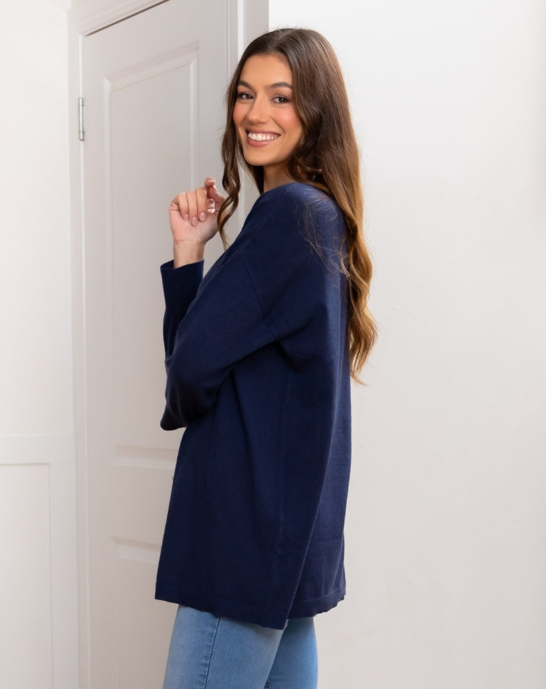 Woman wearing a navy blue cardigan against a white background