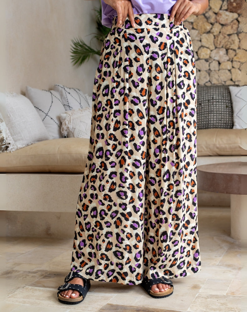Person wearing leopard print pants in a living room setting