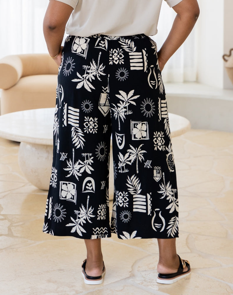 Person wearing black and white patterned pants in a living room setting