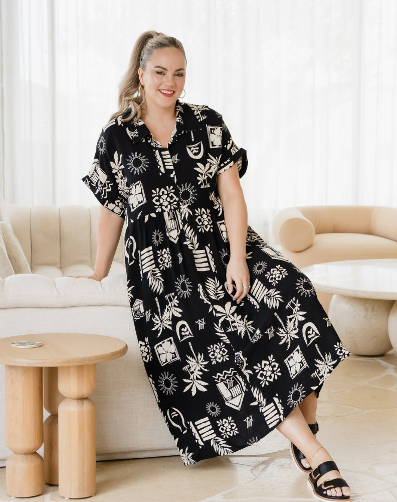 Woman wearing a black floral dress in a living room setting