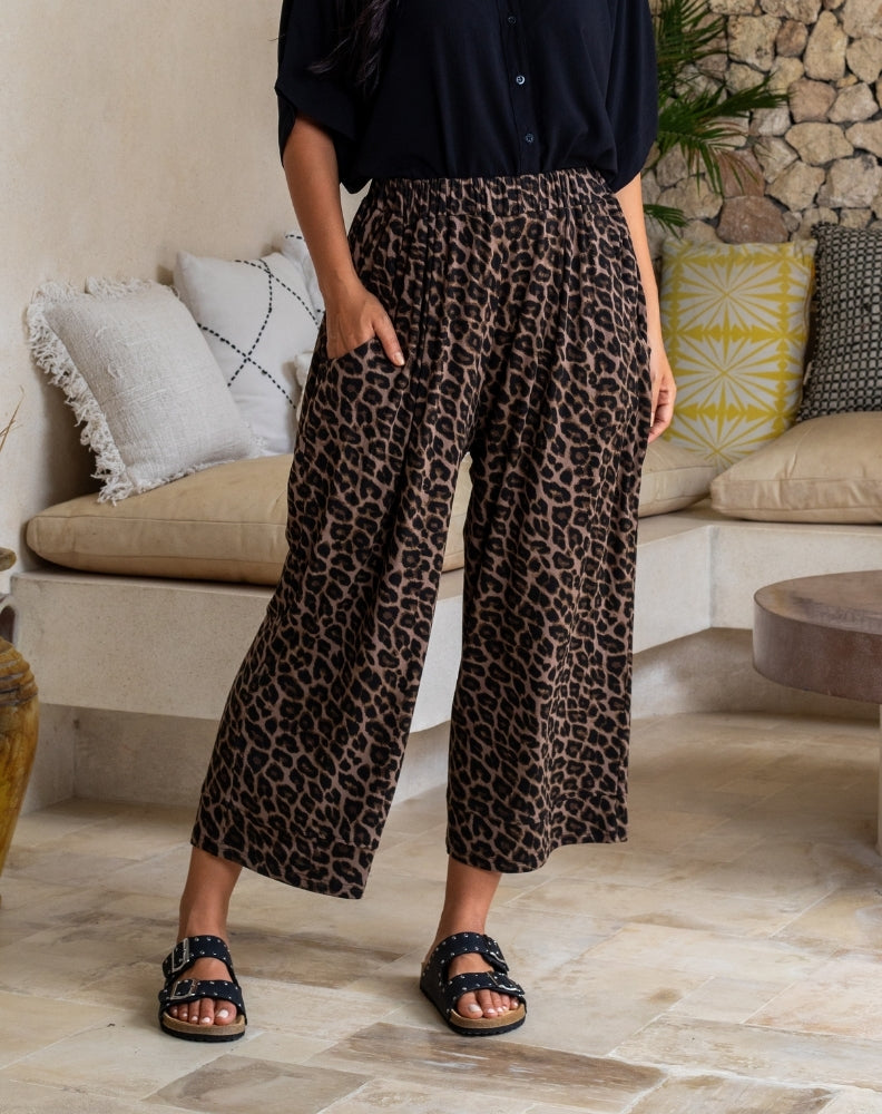 Person wearing leopard print pants in a living room setting