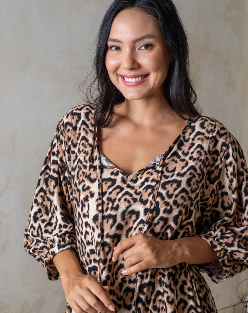 Woman wearing a leopard print dress against a neutral background