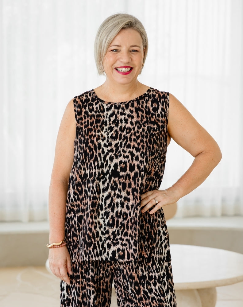 Woman wearing a leopard print outfit in a bright room.