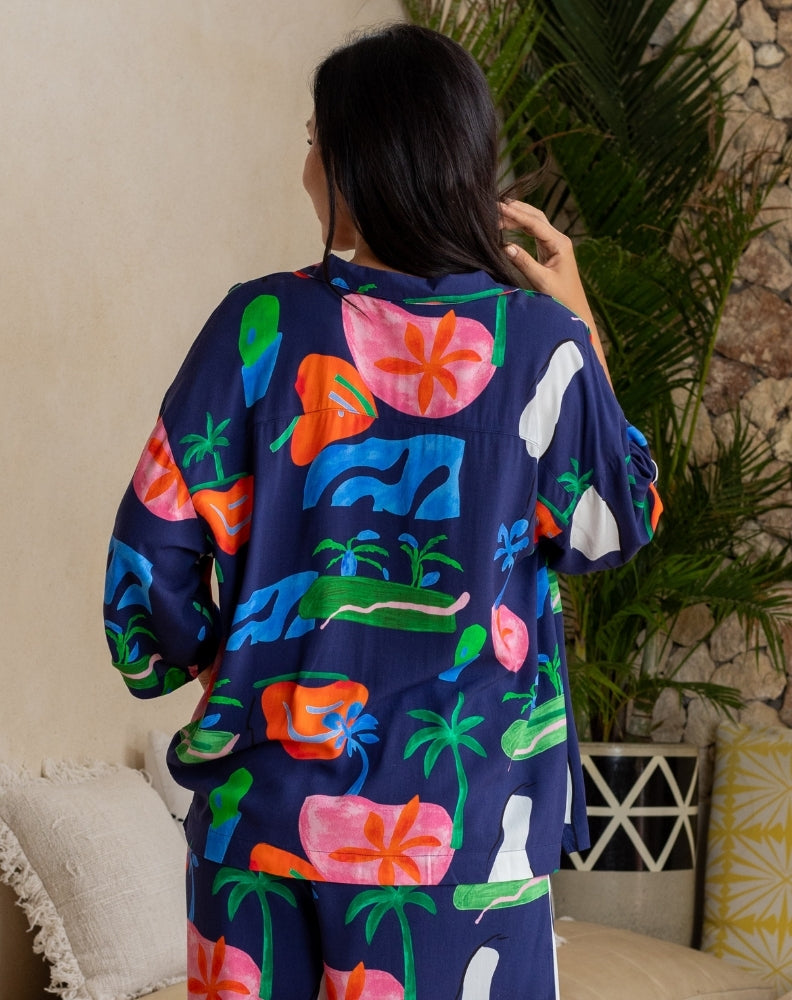 Person wearing a colorful kimono-style garment with abstract designs in a home setting.