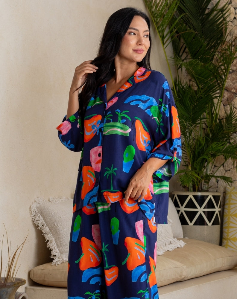 Woman wearing a colorful robe with fruit patterns in a living room setting.