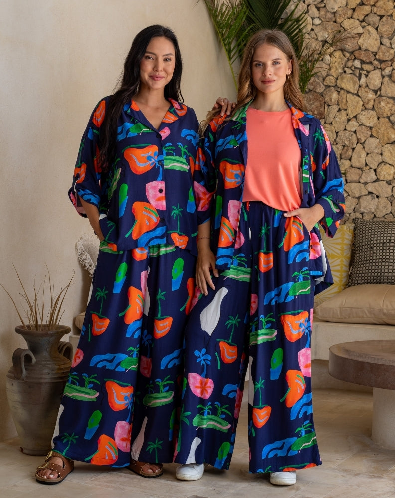 Two women wearing colorful outfits with a floral pattern in a casual setting.