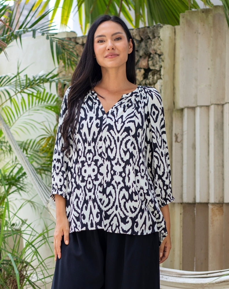 Woman wearing a black and white patterned blouse