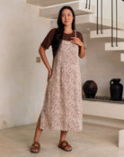 Woman wearing a brown patterned dress in an indoor setting