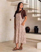 Woman wearing a patterned dress standing in a modern interior setting.