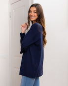 Woman wearing a navy blue cardigan against a white background