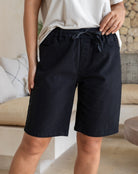 Person wearing black shorts and a white shirt in a casual setting