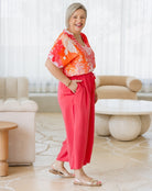 Woman in a colorful outfit standing in a modern living room.