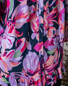 Close-up of a colorful floral dress with a dark background