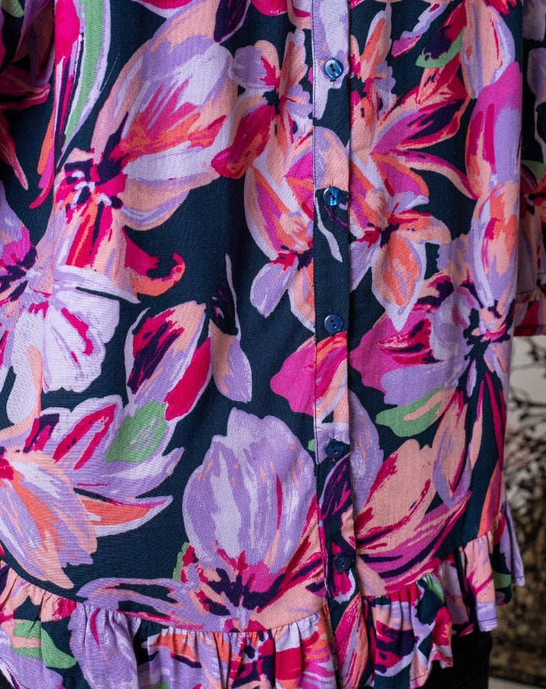 Close-up of a colorful floral dress with a dark background