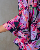 Colorful floral dress with ruffled hem on a neutral background