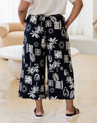 Person wearing black and white patterned pants in a living room setting