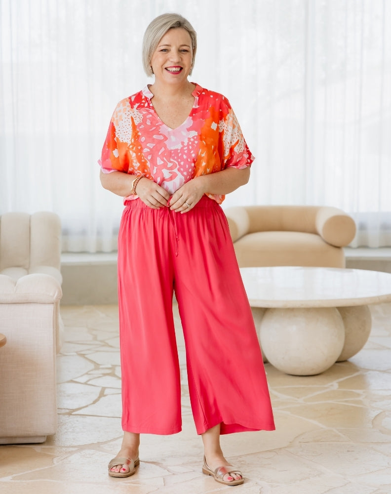Woman wearing a colorful outfit in a living room setting