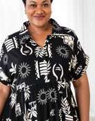 Woman wearing a black dress with white geometric patterns against a white background