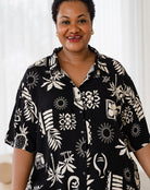 Woman wearing a black and white patterned shirt against a white background
