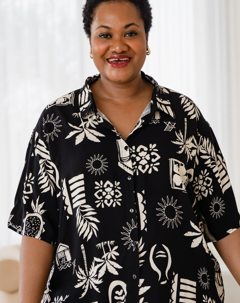 Woman wearing a black and white patterned shirt against a white background