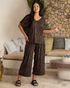 Woman wearing a leopard print outfit in a living room setting