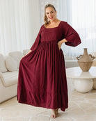 Woman wearing a burgundy dress in a living room setting