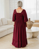 Person wearing a burgundy dress in a living room setting