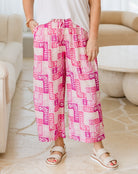 Person wearing pink and white patterned pants in a living room setting