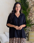 Woman wearing a black shirt with a leopard print bottom in a casual setting.