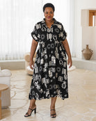Woman wearing a black dress with white patterns in a room with light-colored flooring and decor.