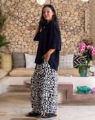 Woman in a stylish outfit standing in a modern living room.