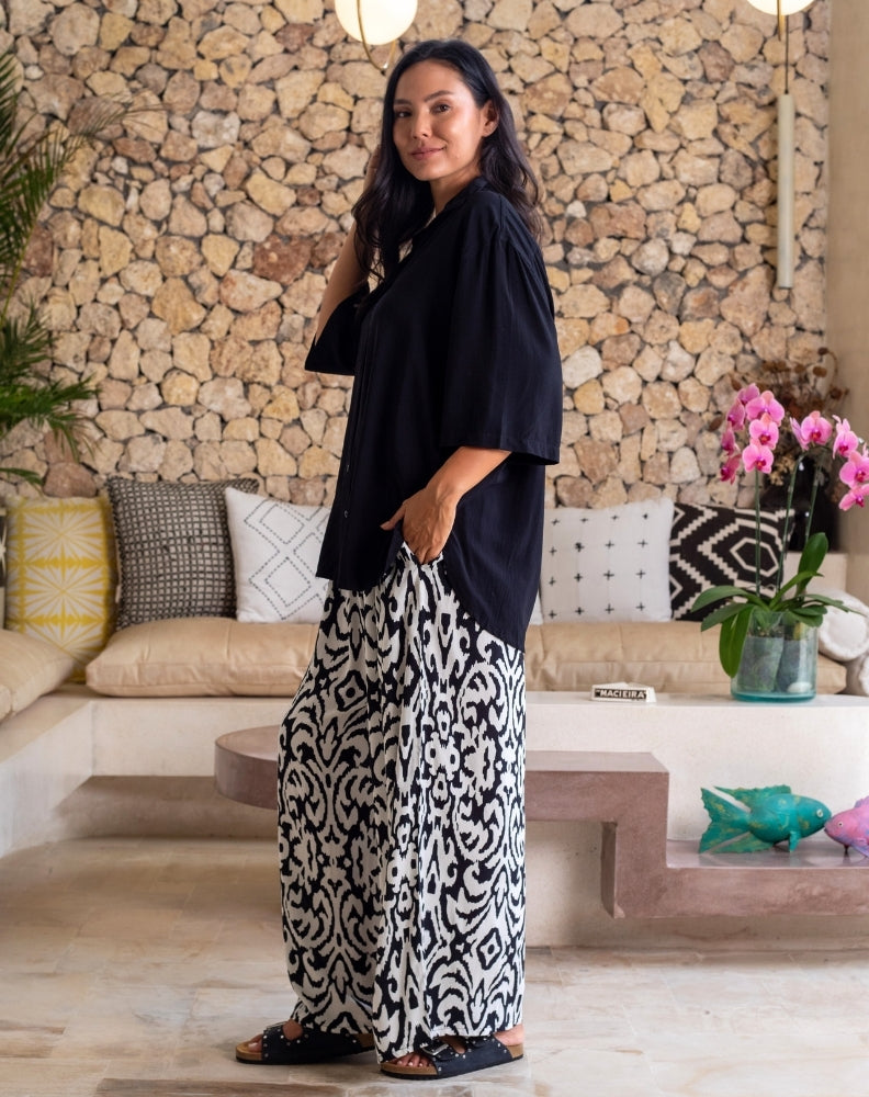Woman in a stylish outfit standing in a modern living room.