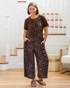 Woman wearing a leopard print jumpsuit in a home setting