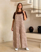 Woman wearing a leopard print jumpsuit in a modern interior setting