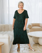 Woman wearing a green dress with a pattern in a living room setting