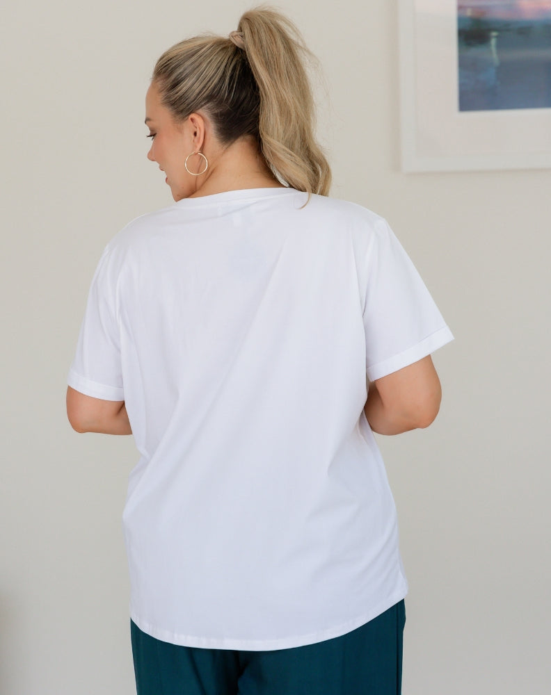 Person wearing a plain white t-shirt in an indoor setting