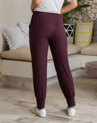 Person wearing maroon jogger pants in a living room setting