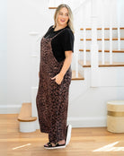 Woman wearing a leopard print dress over a black top in a home setting.