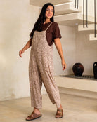 Woman wearing a leopard print jumpsuit and brown top in an indoor setting