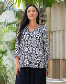 Woman wearing a black and white patterned blouse