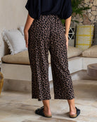 Person wearing leopard print pants in a living room setting