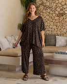 Woman wearing a leopard print outfit standing in a living room.